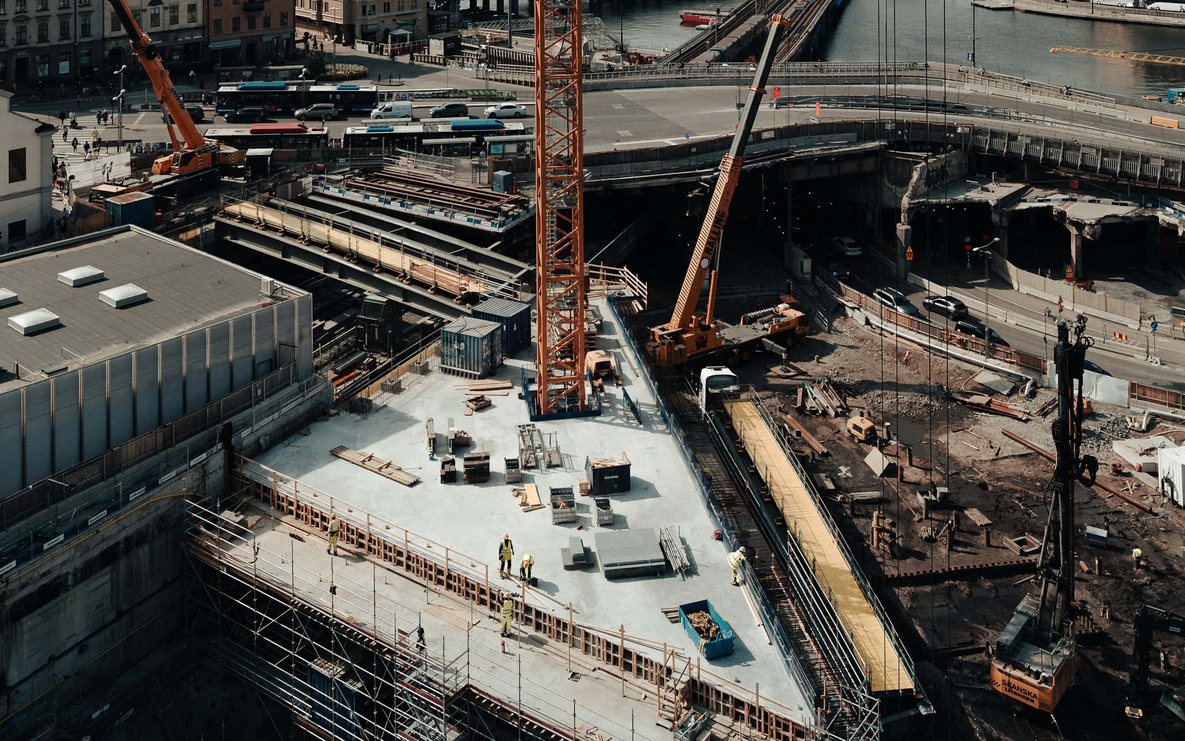 A tower crane standing over an excavated site, work underway below.