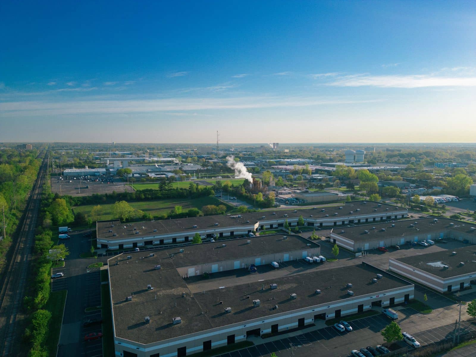 Aerial of a completed commercial park at dusk, loading frontages and parking running to the horizon.